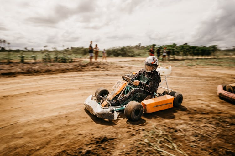 Person Wearing Helmet Racing In Go-Kart