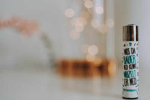 White Labeled Lighter Placed on White Surface