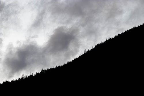 Grayscale Photo of a Mountain under the Cloudy Sky