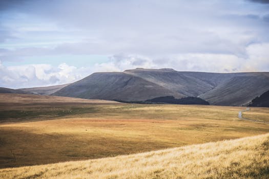 Explore the rolling landscapes of the Brecon Beacons in Libanus, Wales, under a cloudy sky.