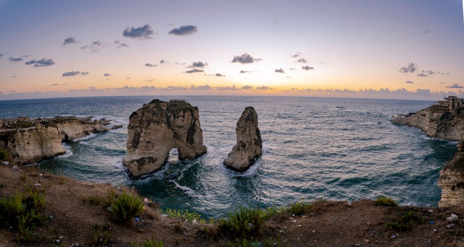 Capture the breathtaking seascape of Raouche's iconic rock formations during a stunning sunset in Beirut, Lebanon.