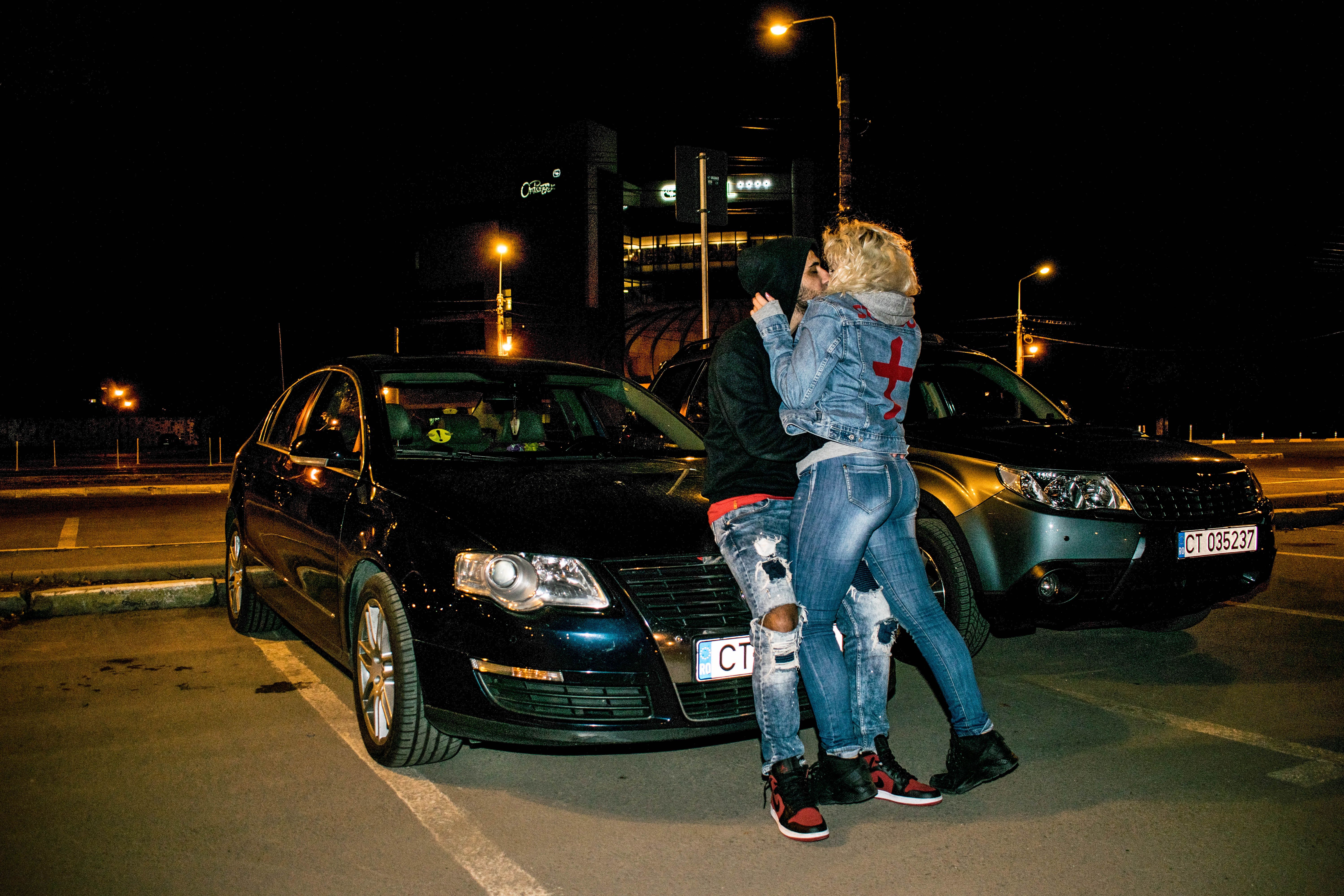 Couple Kissing Beside Black Volkswagen Passat B6 Sedan