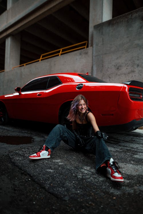 Woman Posing near a Red Car