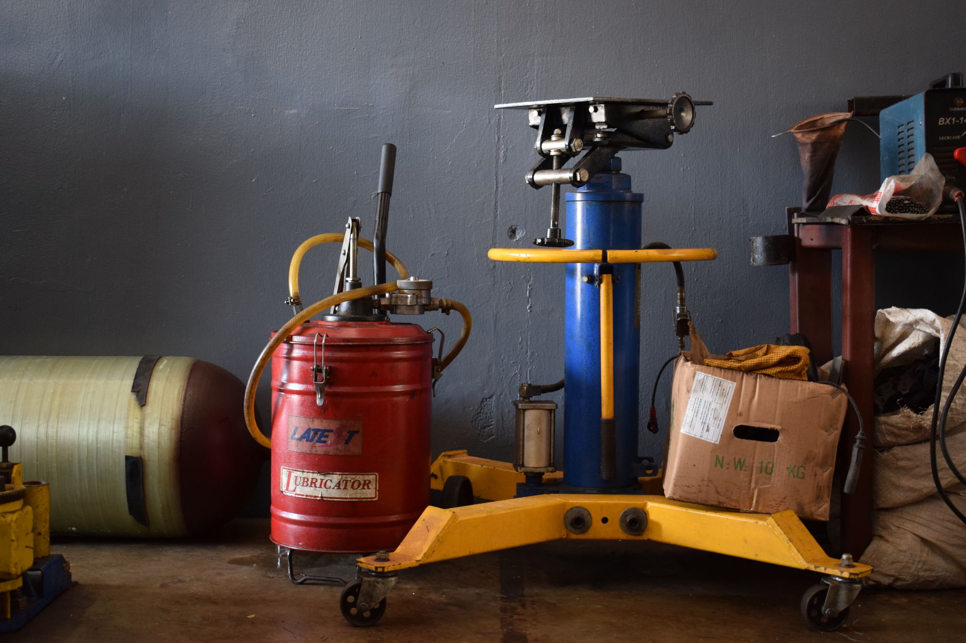 Troubleshooting Shearing Machine Hydraulic Problems插图 A well-equipped workshop features various machinery and an industrial lubricator.