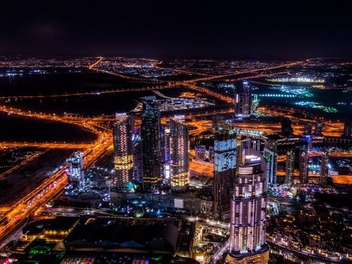 Free Stunning aerial view of Dubai's illuminated skyline and highways at night. Stock Photo