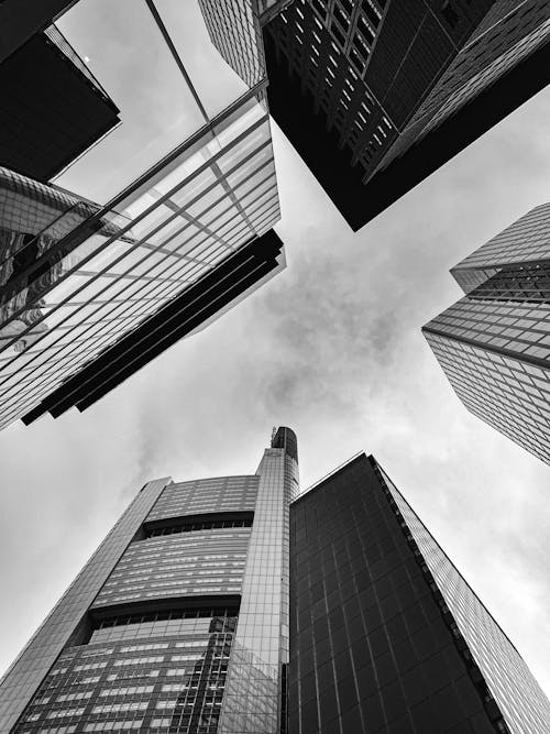 A Grayscale Photo of City Buildings Under the Cloudy Sky