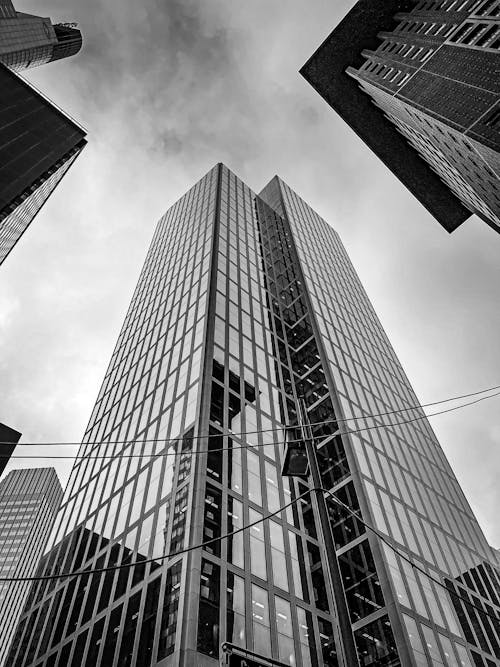 A Grayscale Photo of City Buildings Under the Cloudy Sky