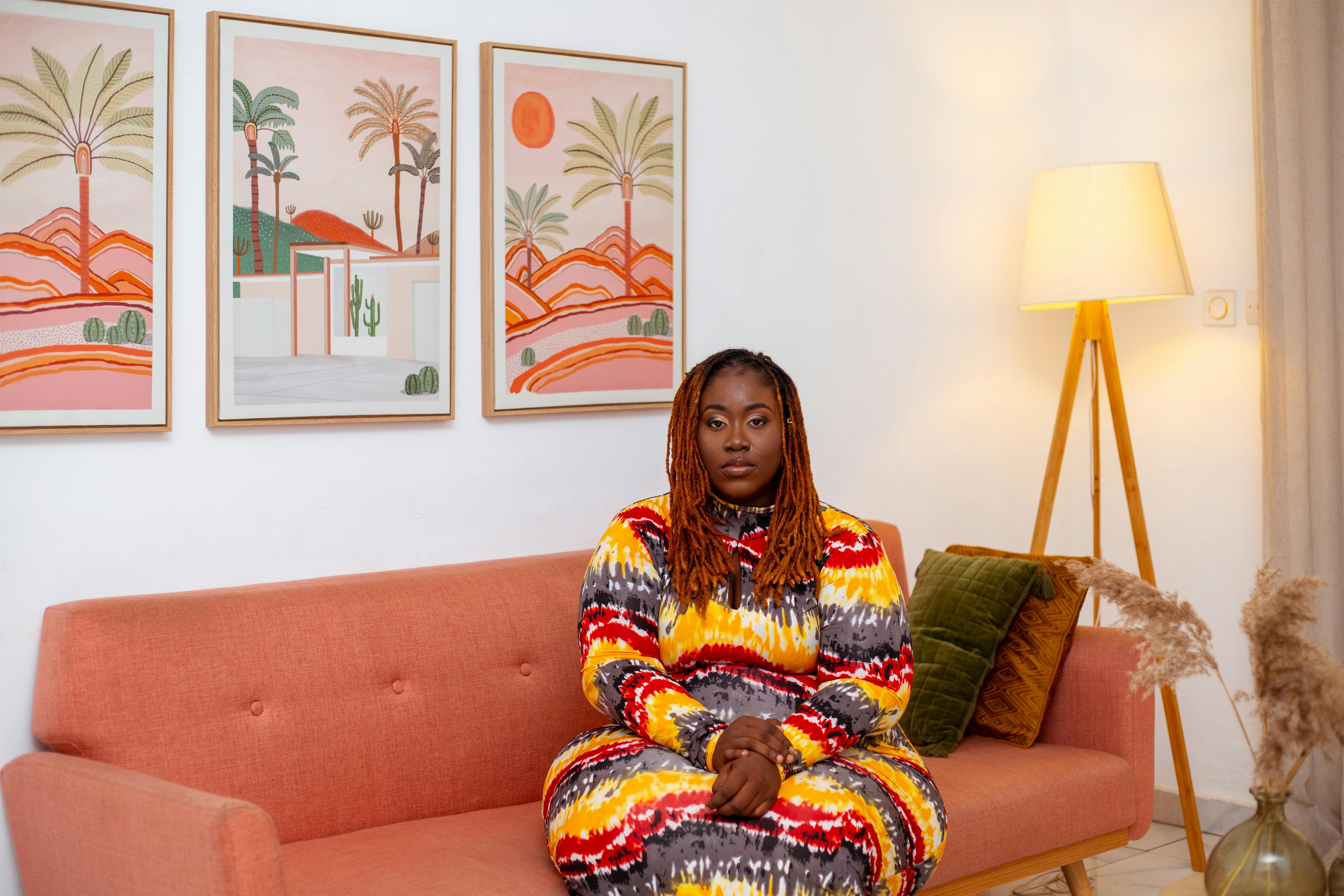 a woman in colorful dress sitting on a couch