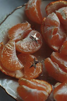 Fresh orange slices with festive star decorations on a plate.