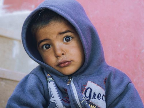 Free Captivating close-up of a child in a hoodie showing a curious expression. Stock Photo