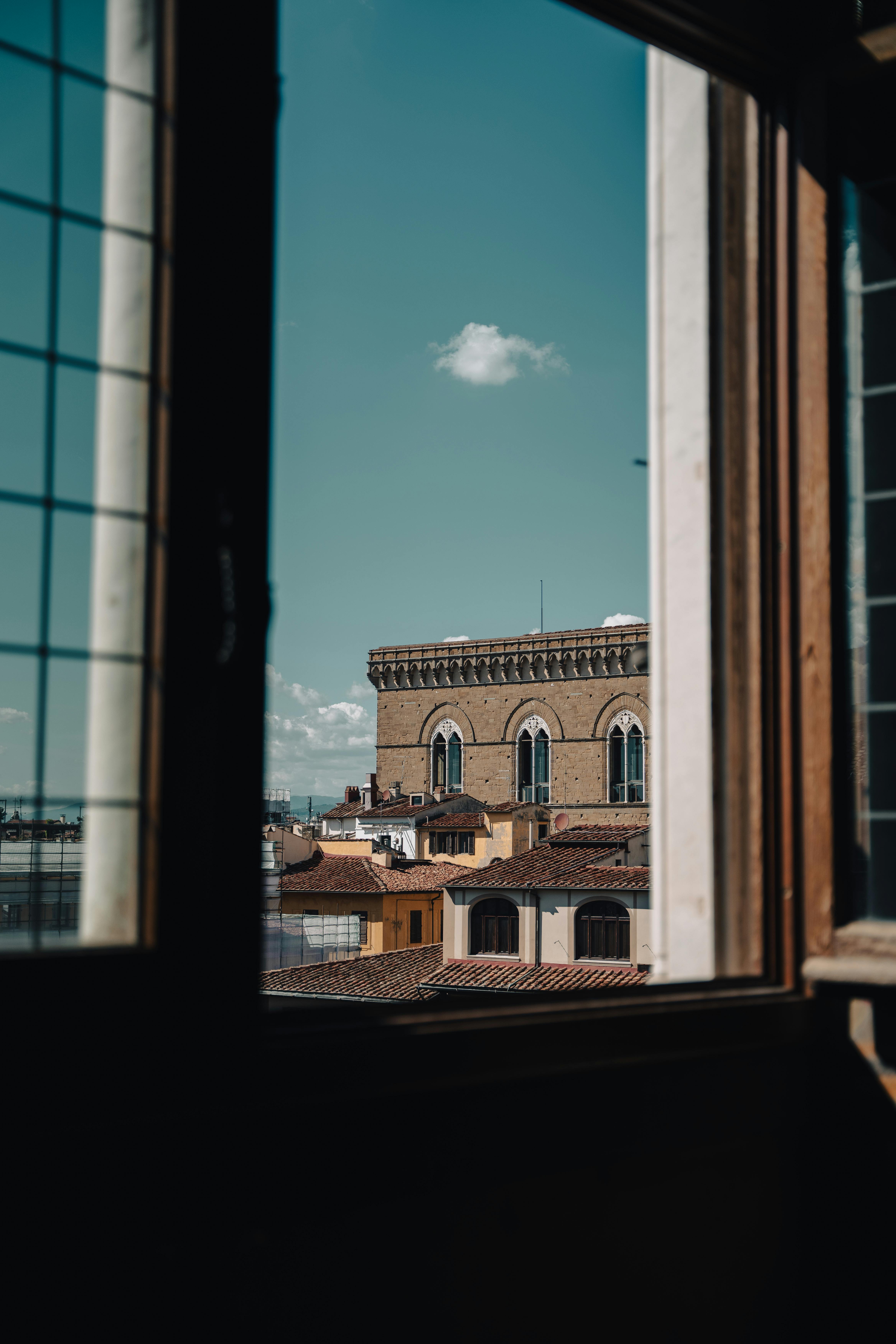 View of Florence's historic architecture through an open window, capturing city charm.