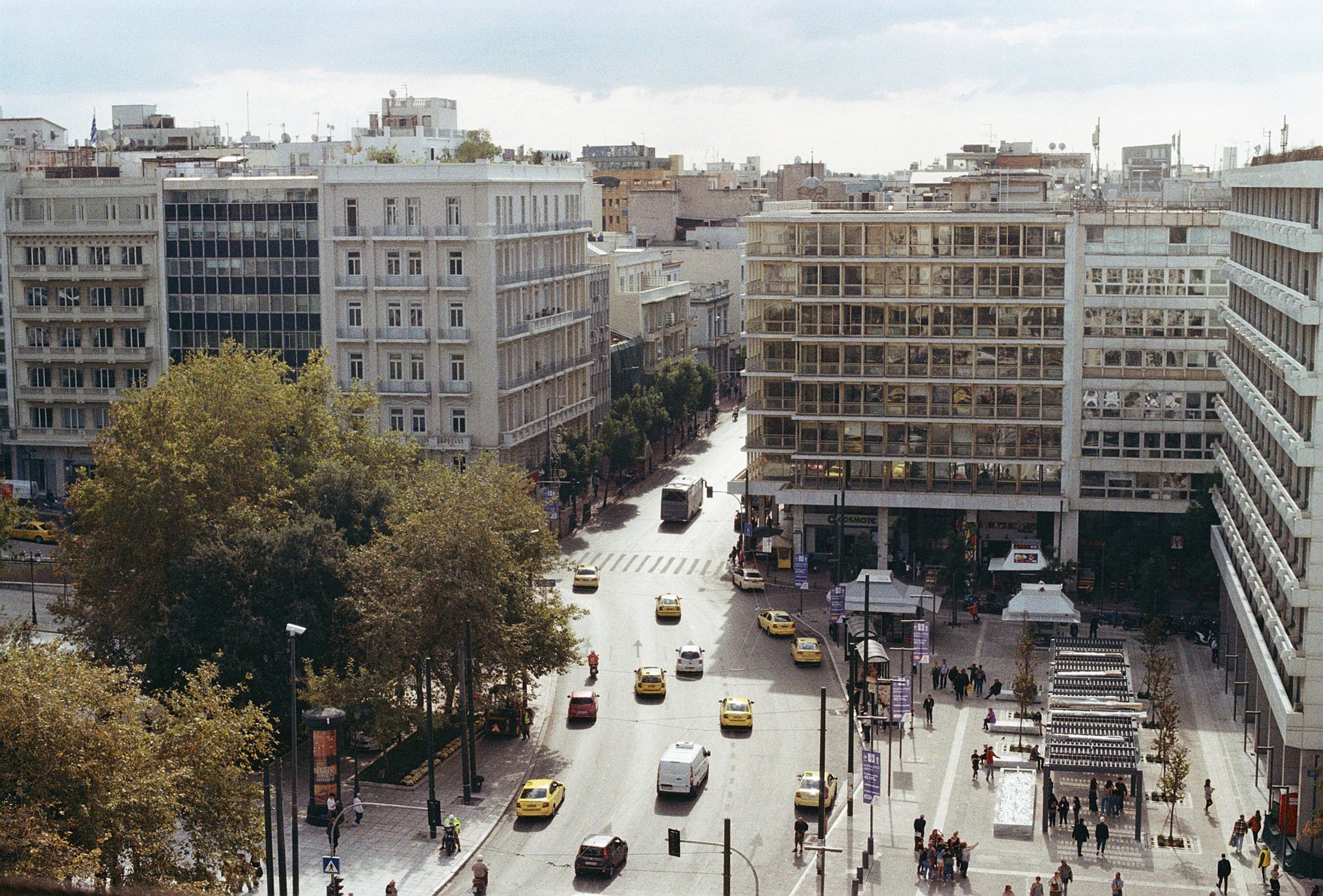 A bustling urban street view in downtown Athens, Greece, showcasing modern architecture and lively city life