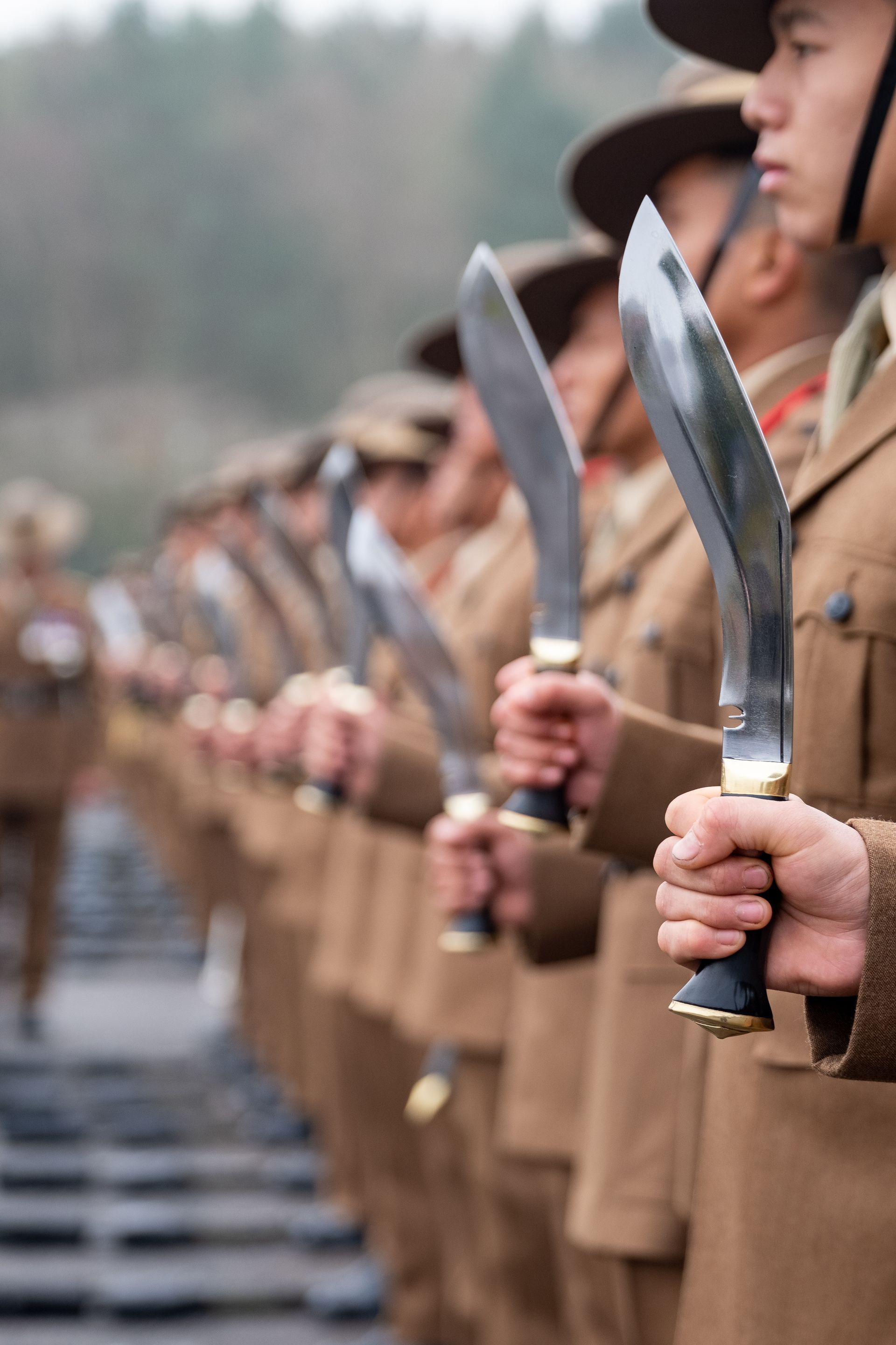 Row of Gurkha soldiers holding kukri fighting knives in formation