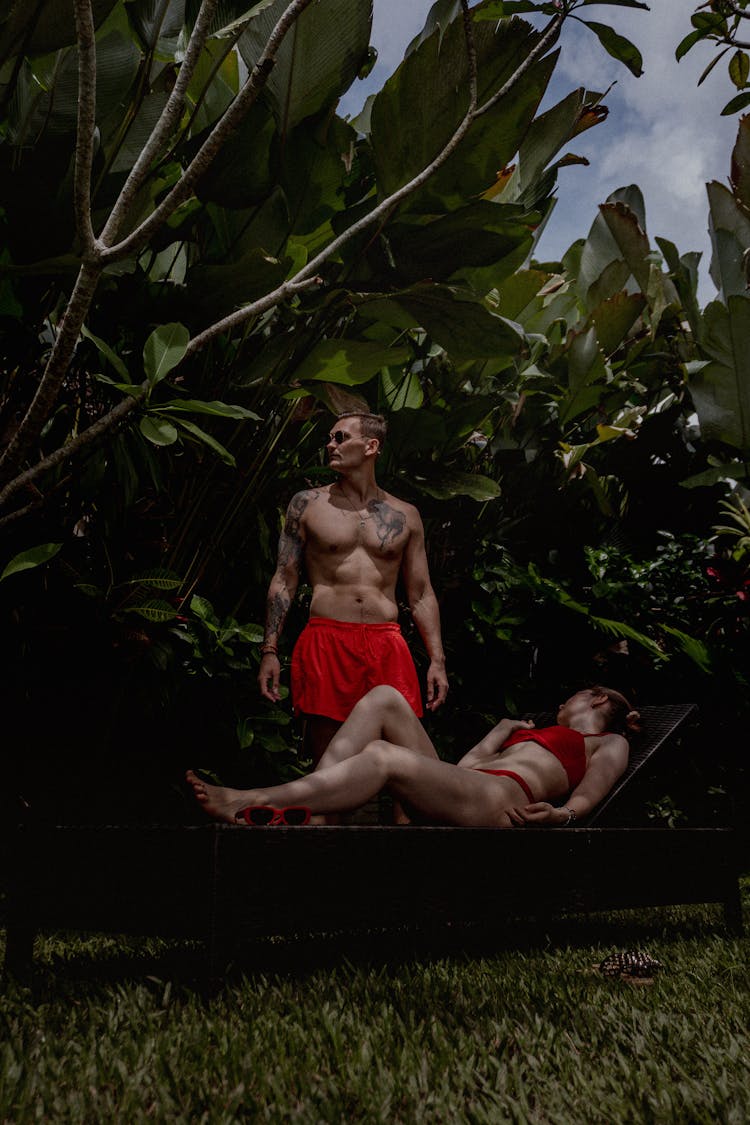 Couple In Swimwear Sunbathing In Garden