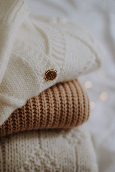 Stack of cream and camel knitwear — photo by Nati on Pexels