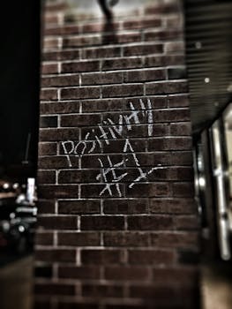 在多伦多被捕时，夜间的城市环境中有一面带有“积极性 #1”涂鸦的砖墙