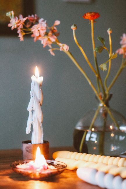 Warm, cozy still life composition with candles and flowers creating a serene ambiance.