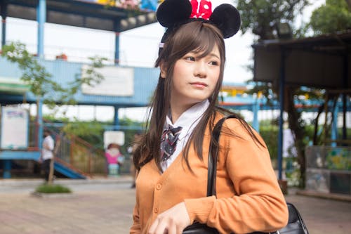 Free Woman Carrying Black Bag and Wearing Minnie Mouse Headband Stock Photo