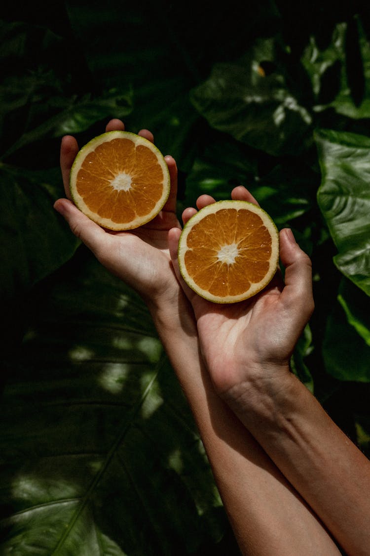 A Person Holding Sliced Citrus Fruit