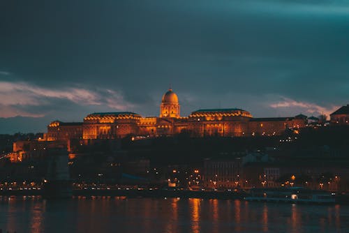 Illuminated Buda Castle seen from the Danube River in Budapest, Hungary 