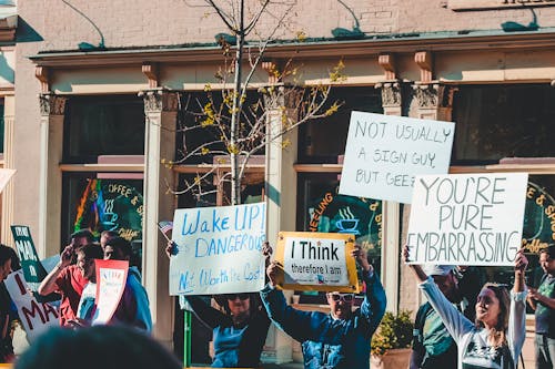 People Holding Signs With Text on Protesting