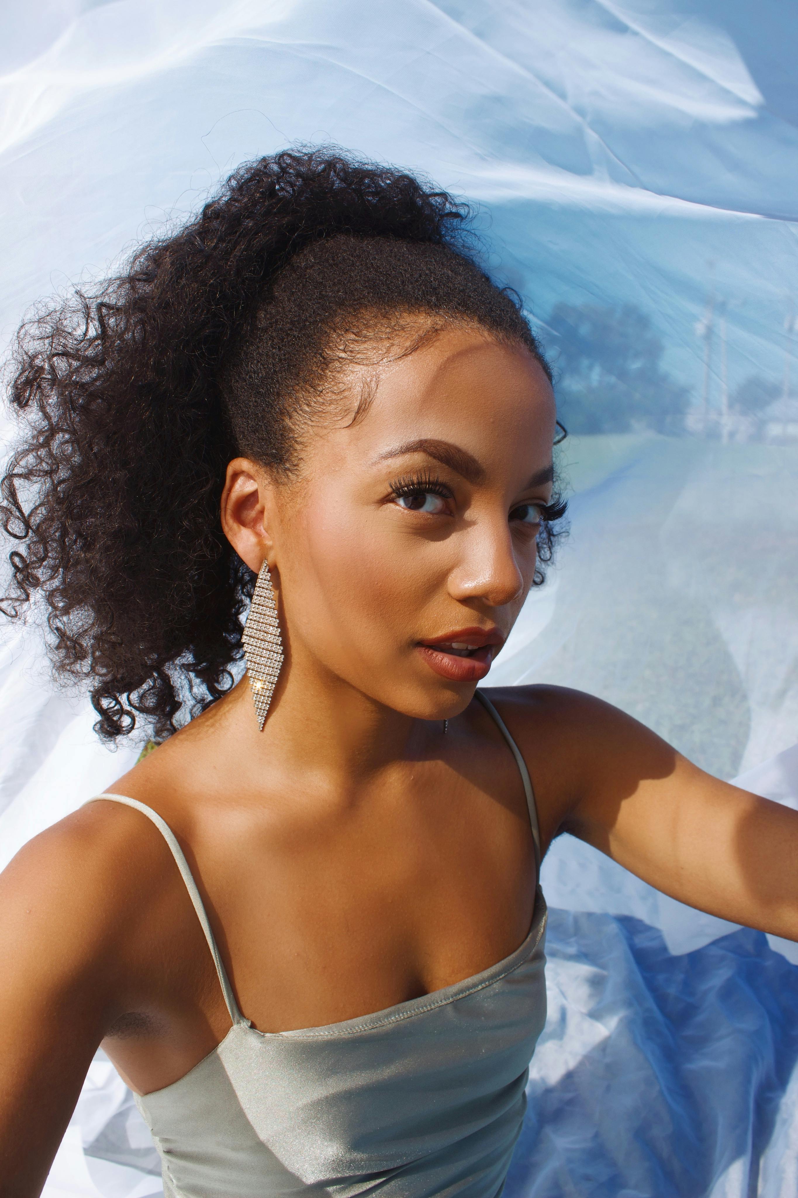 Beautiful portrait of a stylish African American woman with jewelry outdoors in natural light.