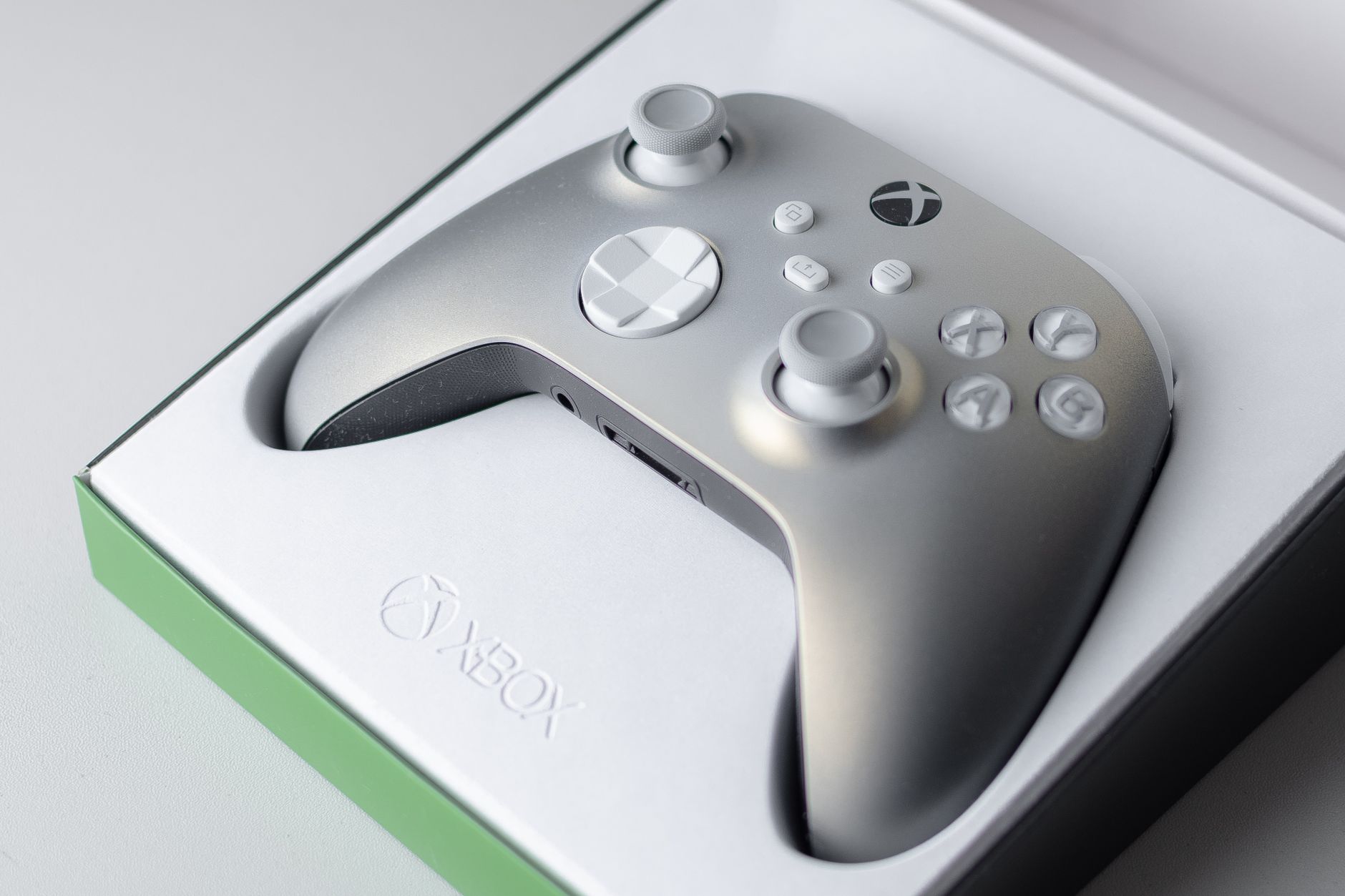 A high-quality close-up of an Xbox game controller in its packaging box, ready for gaming.