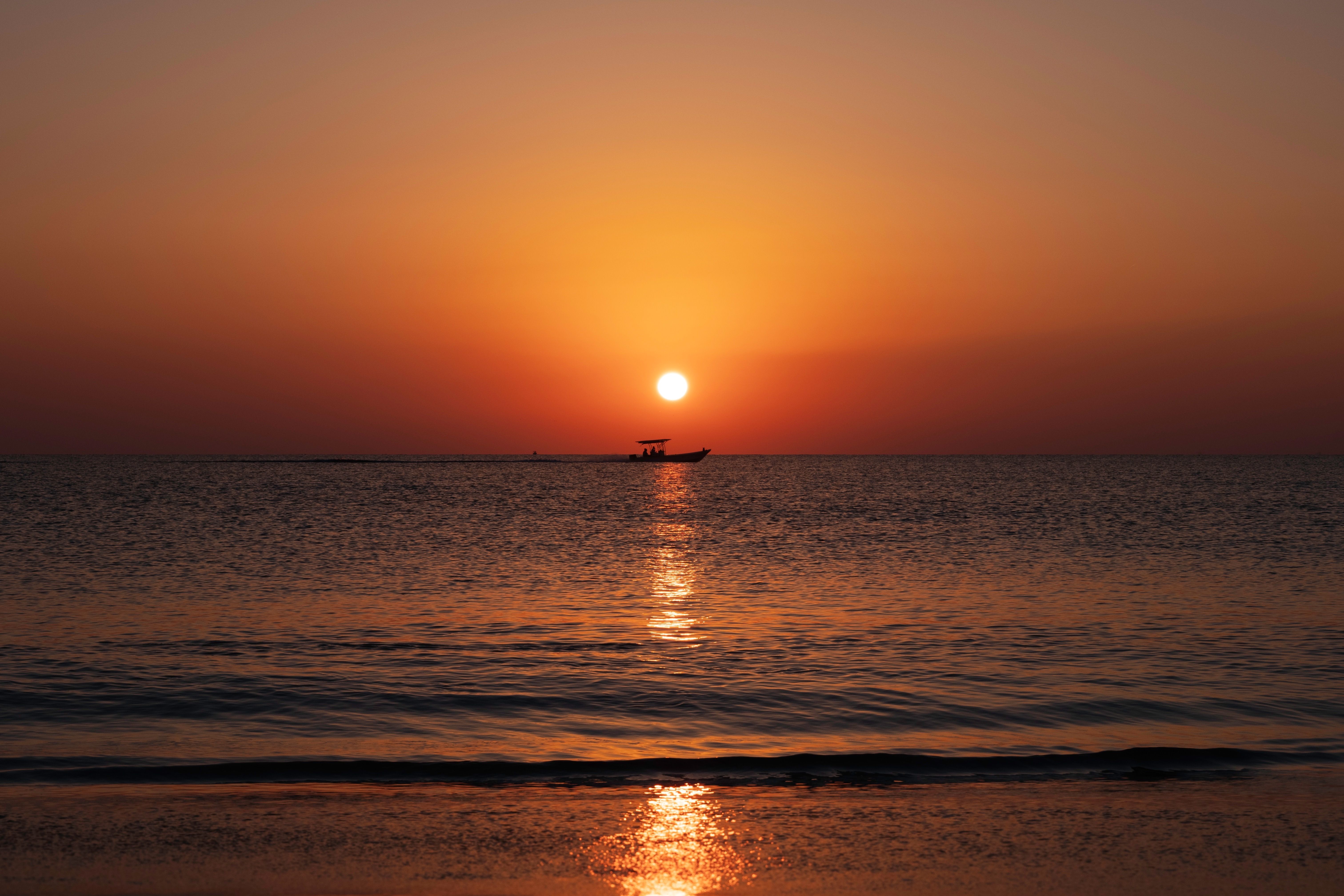 A Silhouette of a Boat on the Sea During Sunset · Free Stock Photo