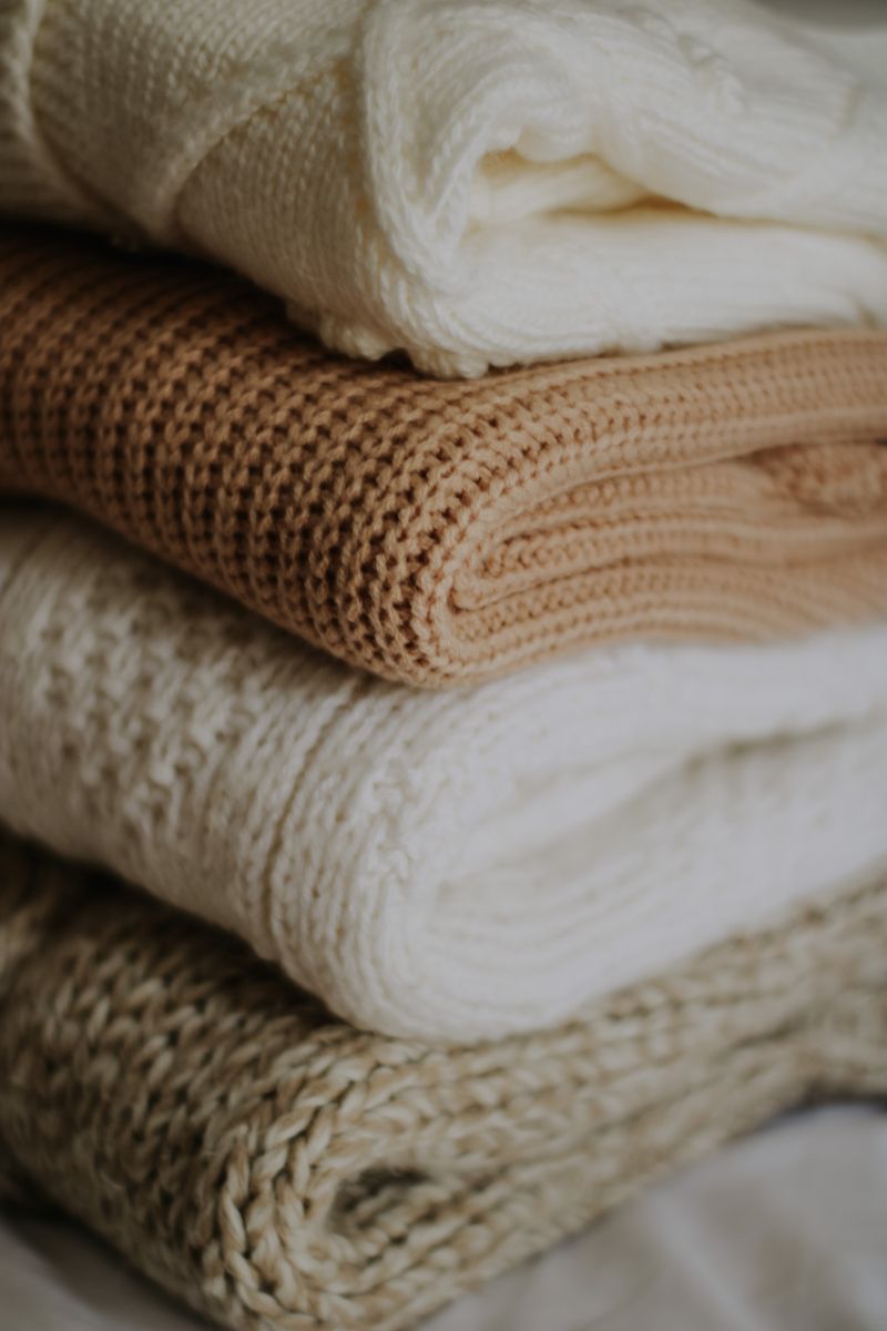 Stack of folded beige knitted blankets, by Nati on Pexels