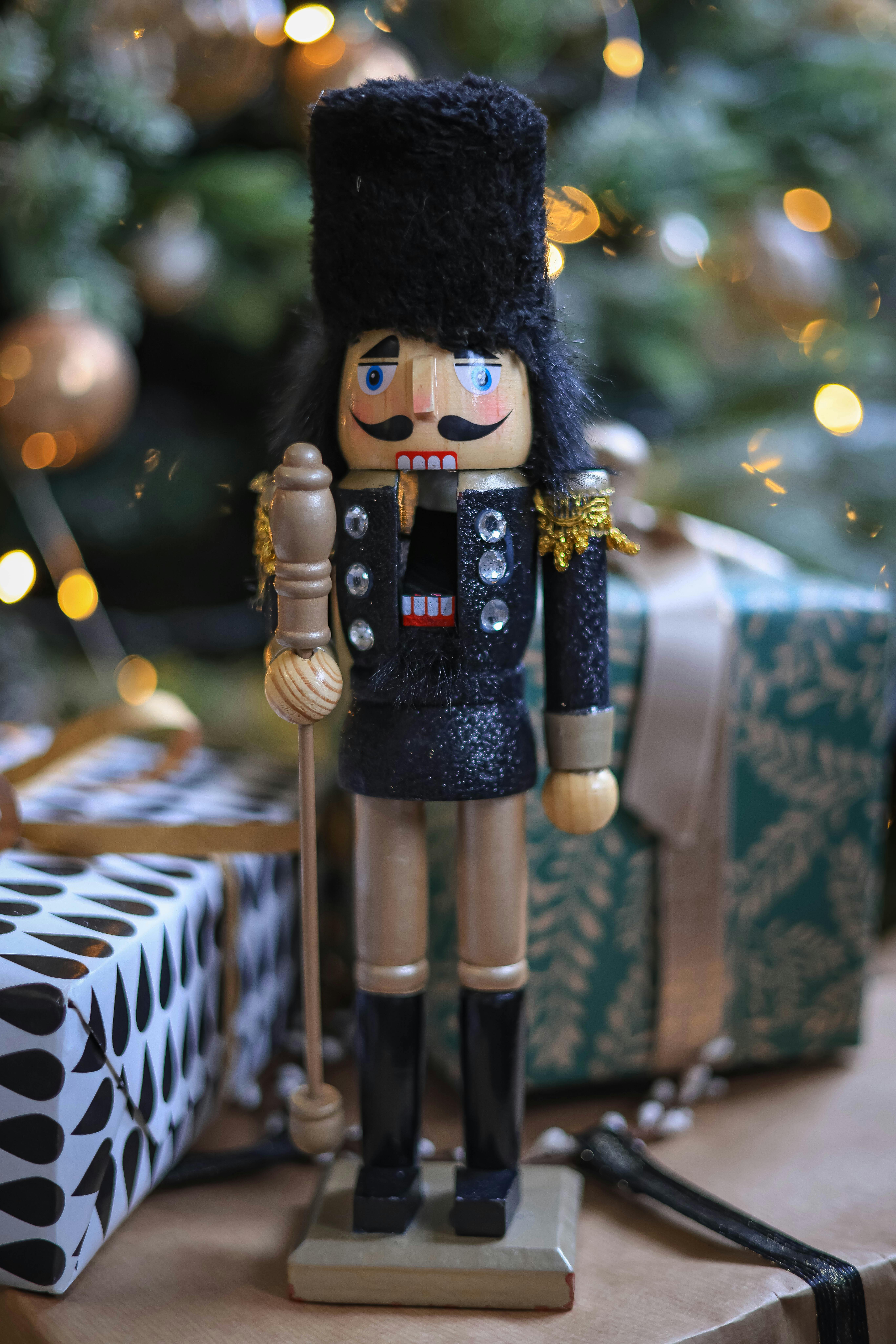 A Wooden Nutcracker Near Christmas Gifts · Free Stock Photo