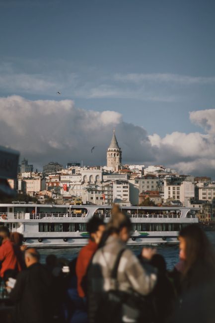 Bustling Istanbul scene featuring Galata Tower and a ferry on the Bosphorus.