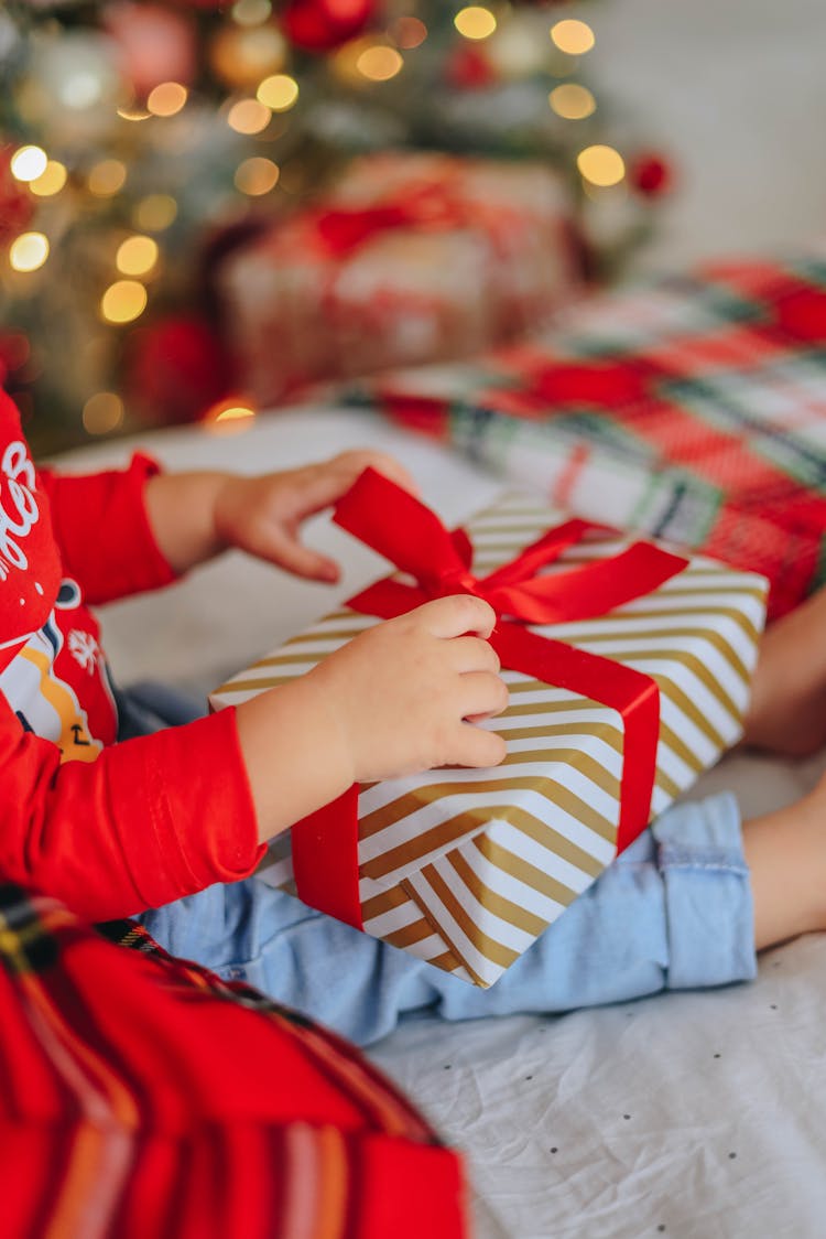 Girl Unwrapping Gifts Near Christmas Tree