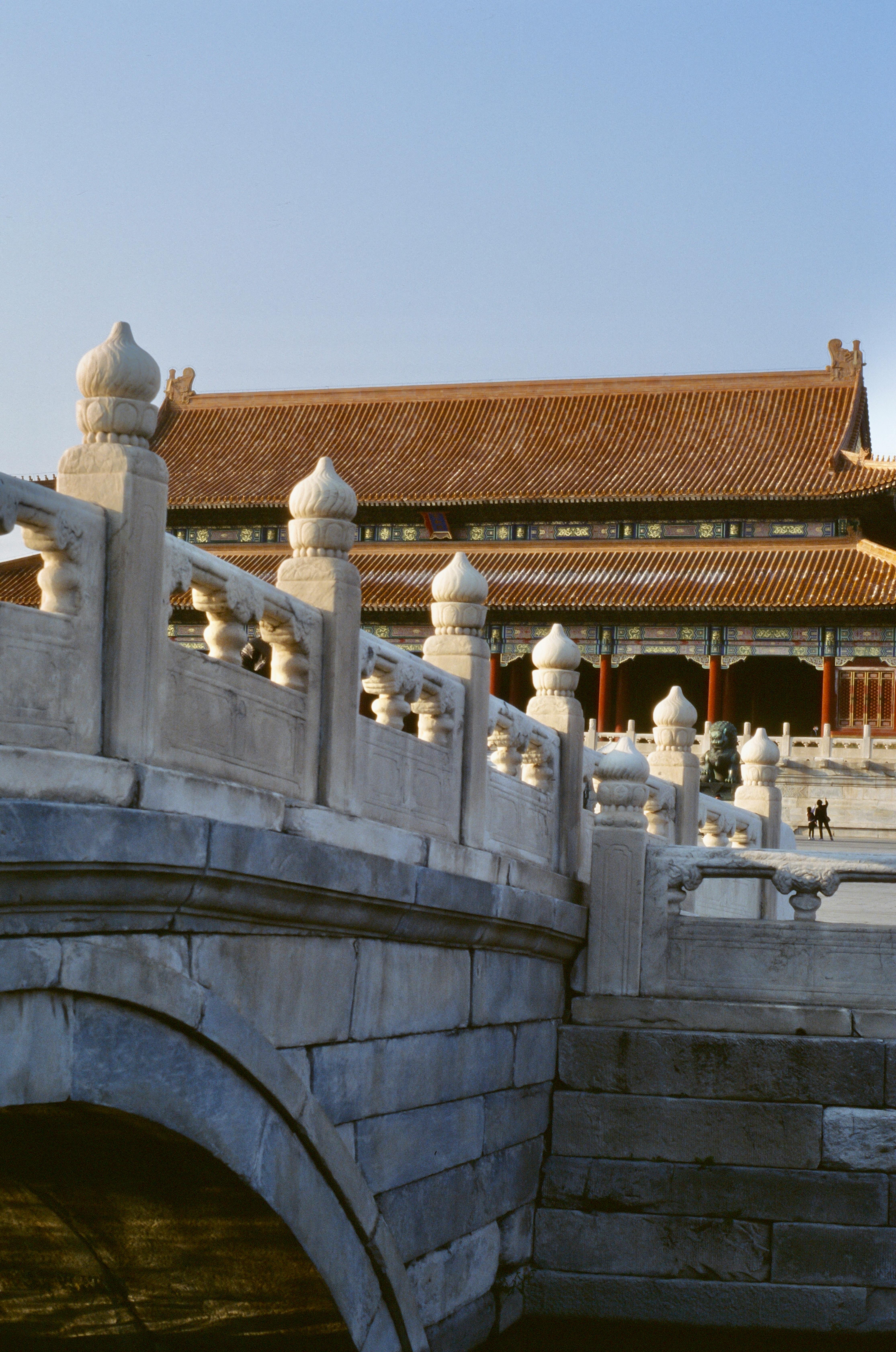 View of traditional Chinese architecture with a stone bridge in Beijing's Forbidden City.