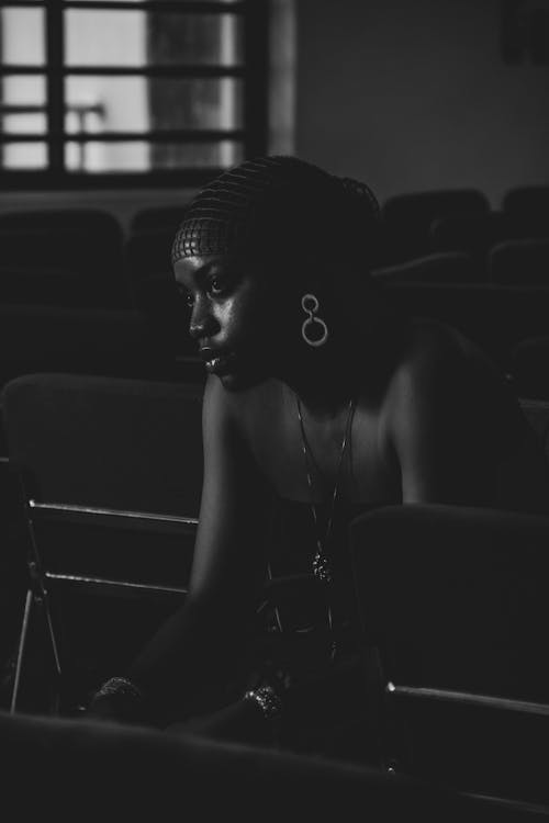 A Serious Woman Sitting on a Chair while Looking Afar