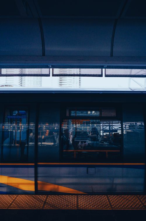 Free Urban train reflections at a Vancouver station showcasing architecture and city life. Stock Photo