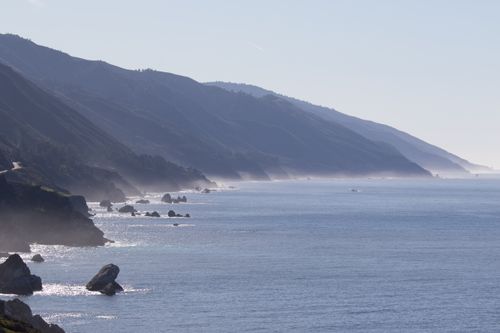 Free Serene coastal view featuring rocky shoreline and hills, perfect for nature enthusiasts. Stock Photo