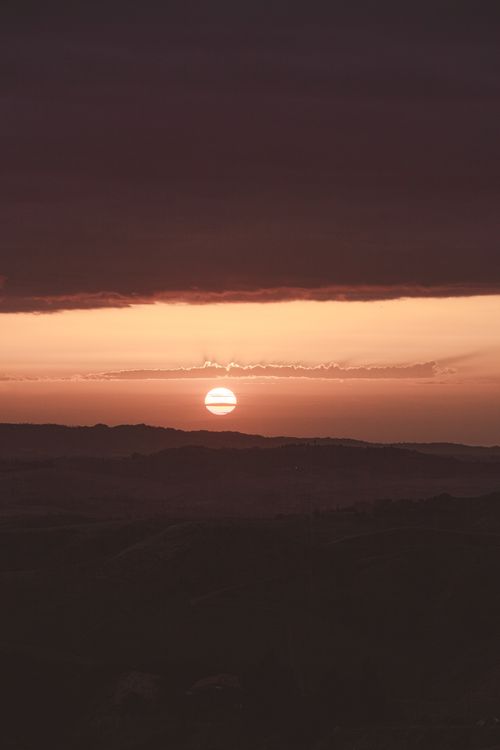 Free A breathtaking sunset with vibrant hues over serene rolling hills, perfect for serene and tranquil themes. Stock Photo
