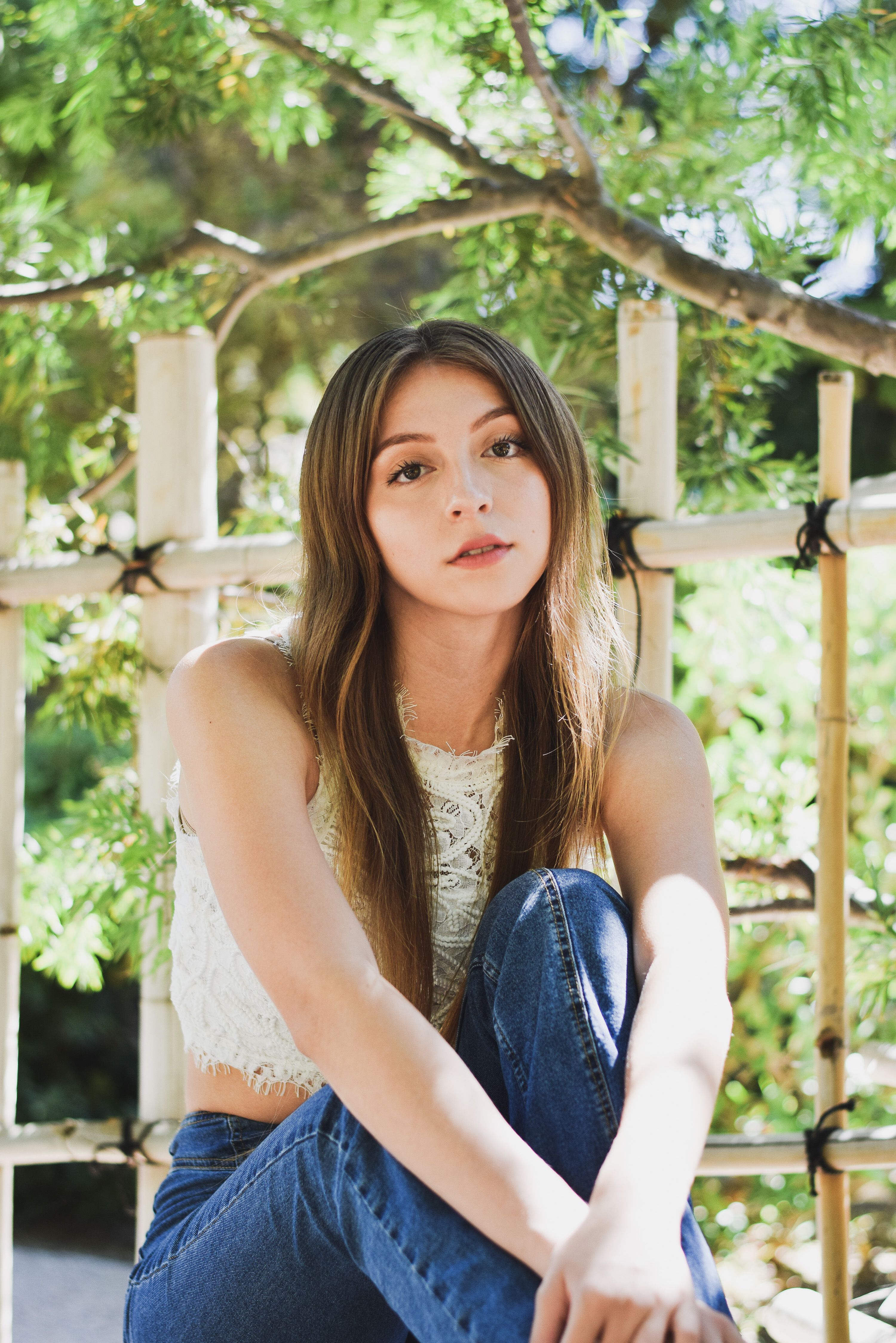 Woman Sitting on Chair Wearing Jeans and Top · Free Stock Photo