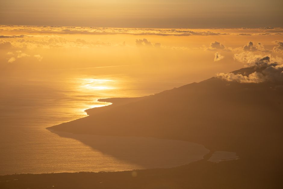 Amazing Maui Gyrocopter Flight with Ocean and Mountain Views Review Review 2026 - Breathtaking aerial vista of a sunlit coastline at sunset with dramatic clouds.