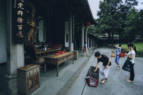 Free Visitors explore a traditional Chinese temple, showcasing cultural architecture and spirituality. Stock Photo