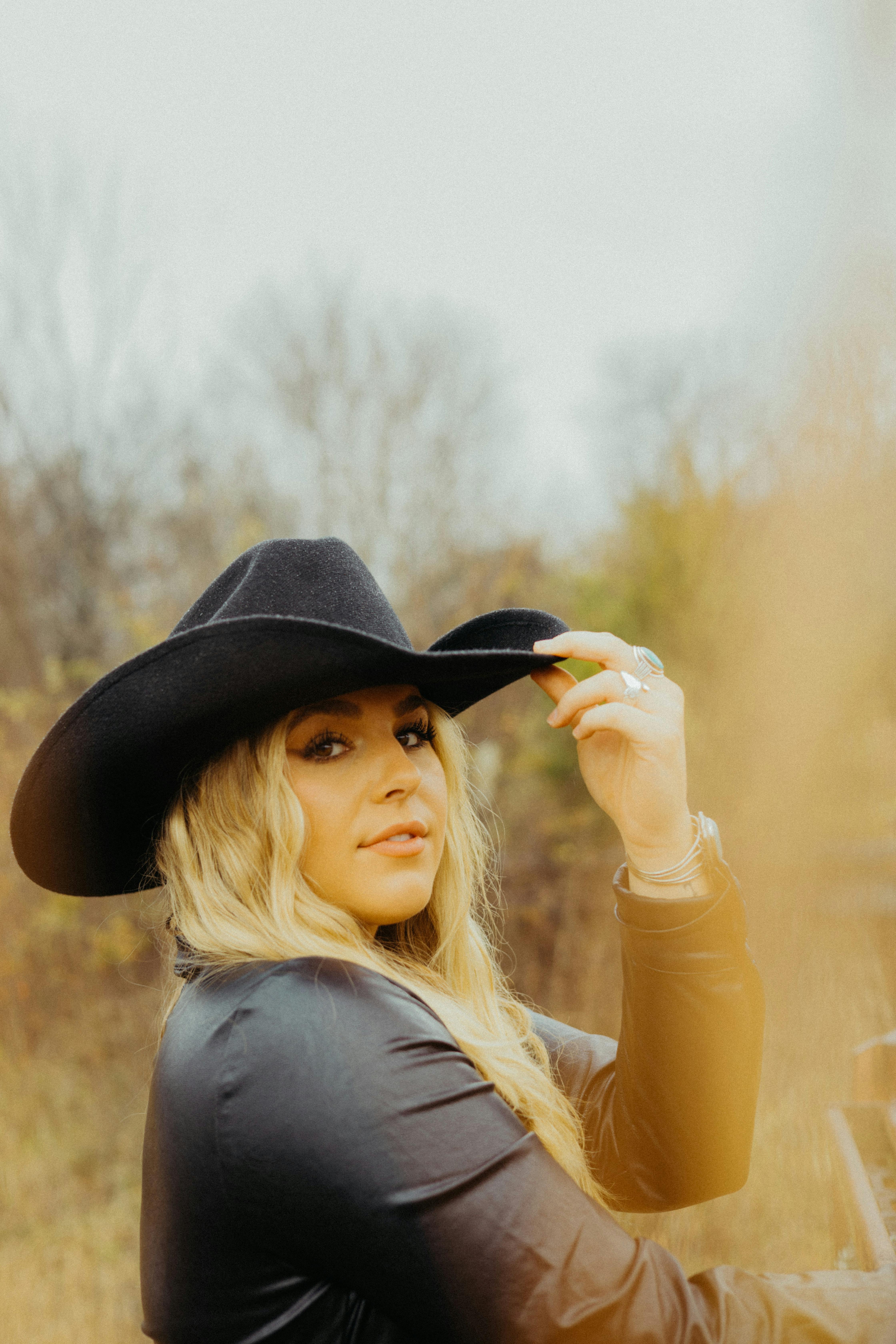 Woman in Black Long Sleeve Shirt Wearing Black Cowboy Hat · Free Stock