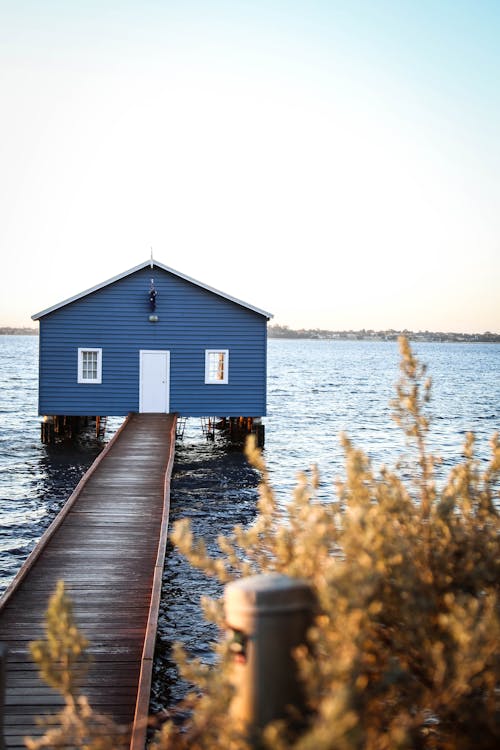 Rumah Dengan Dock Di Badan Air Di Bawah Langit Biru Dan Putih