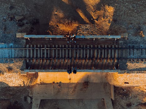 Top view of people sitting on a railway bridge in Biskra, Algeria, captured by drone.