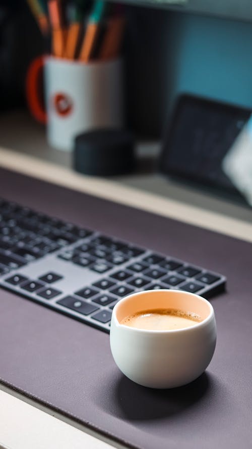 A Cup of Coffee Near a Keyboard