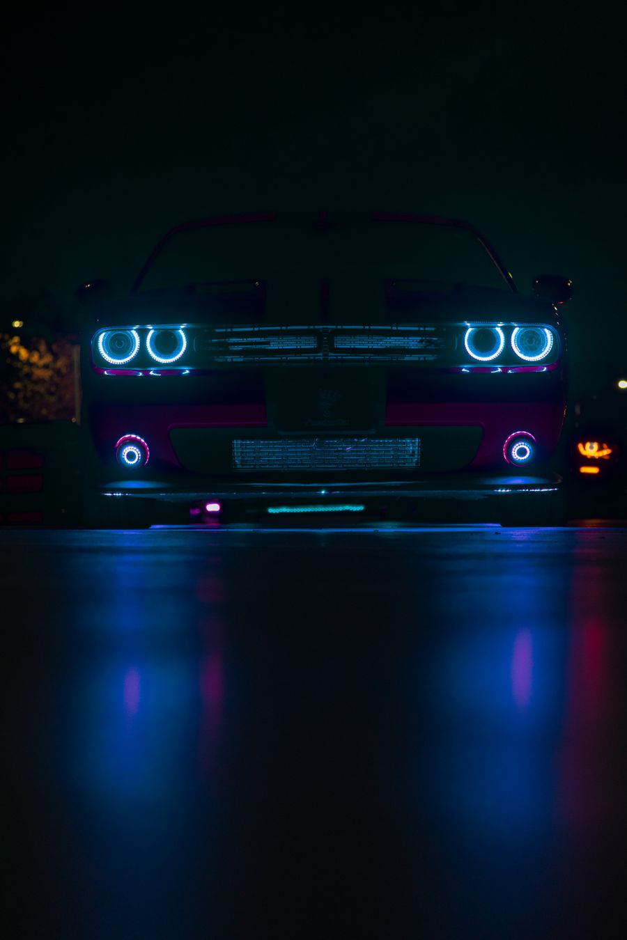 Muscle car with glowing headlights at night