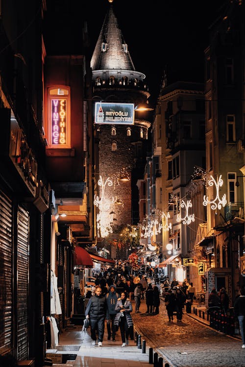 People Walking on the Street at Night Near the Galata Tower