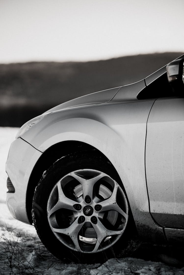 A Grayscale Of A Wheel Of A Car