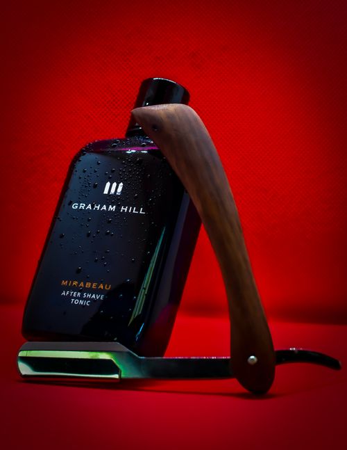 Free Close-up of Graham Hill aftershave and vintage razor on a red background Stock Photo