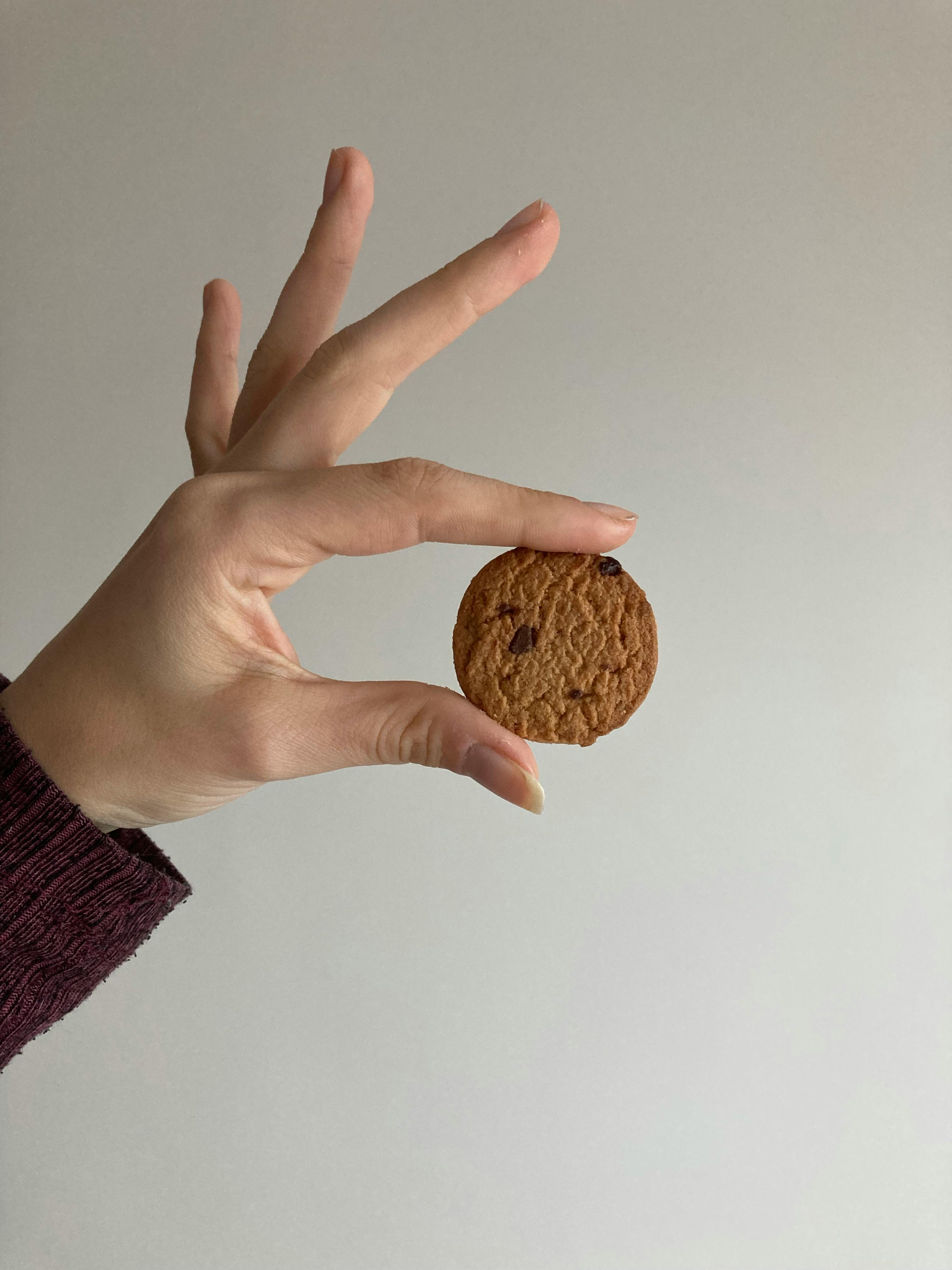 close up of woman holding a small cookie
