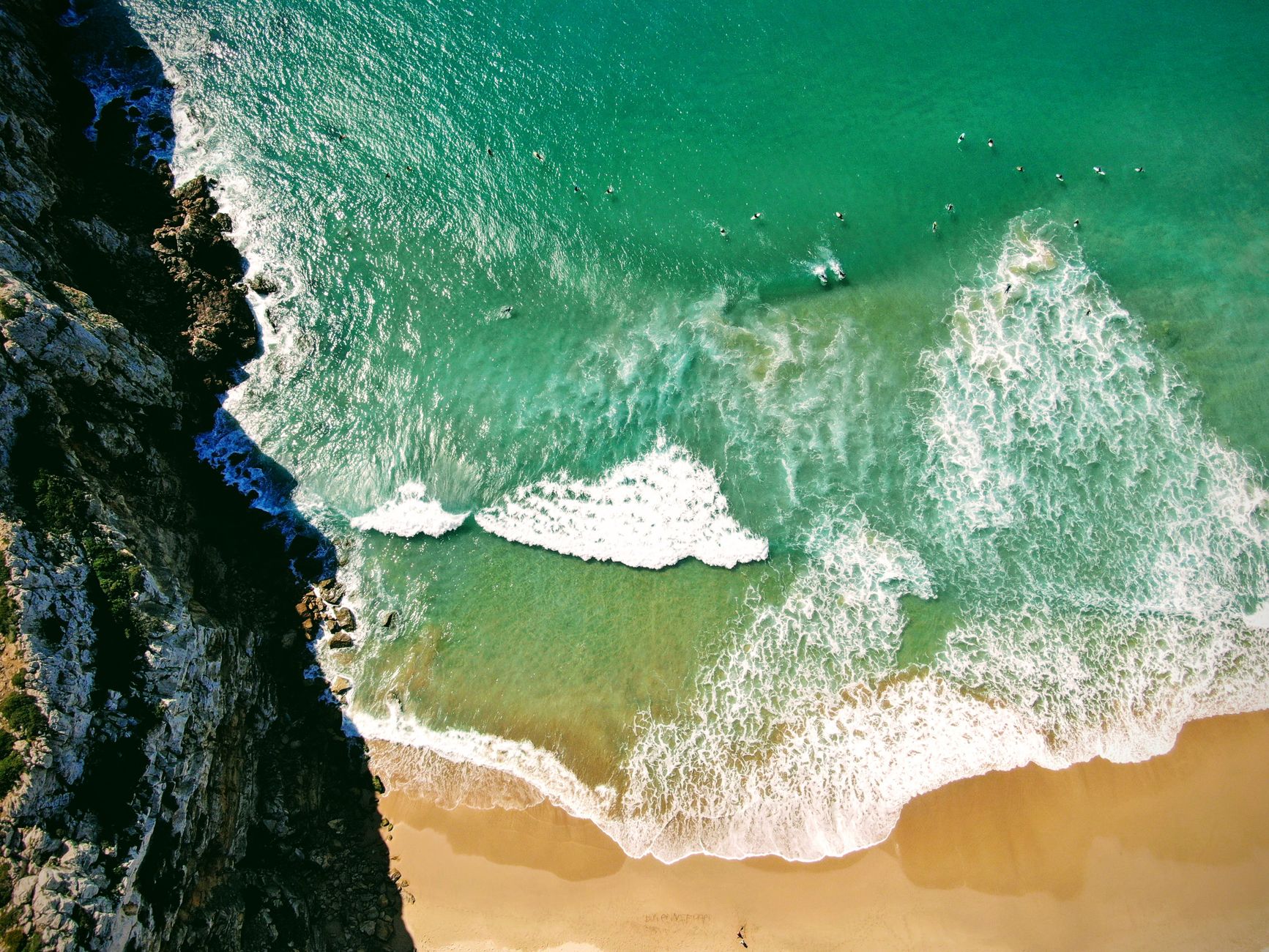 A stunning aerial view of Sagres beach in Portugal, showcasing turquoise waters, sandy shores, and dramatic cliffs.